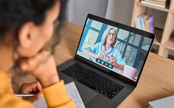 Mulher conversando com outra mulher via notebook