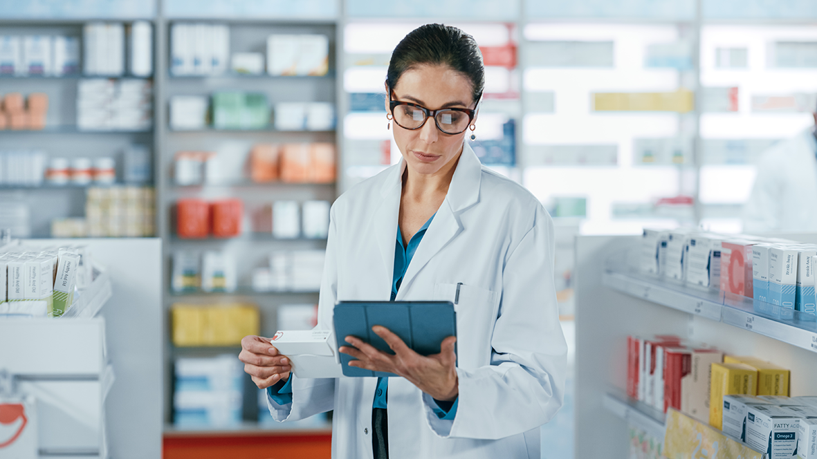 Farmacêutica lendo receita, em pé, dentro de farmácia