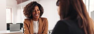 Mulher colaboradora conversando com outra mulher do RH sobre benefícios corporativos